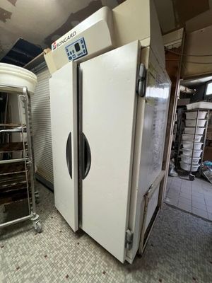 two refrigerators that are sitting in a room