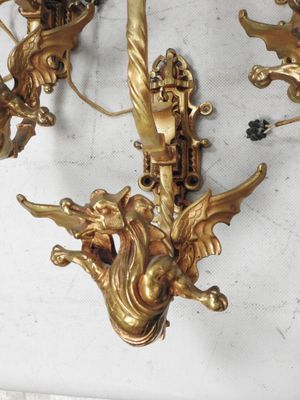 quatre appliques dorées posées sur une table blanche