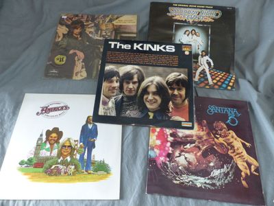 a lot of records on a bed with a blue sheet