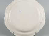 underside view of a plate showing the scalloped edge