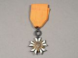 l'image d'une médaille ornée d'une étoile, posée sur une surface grise