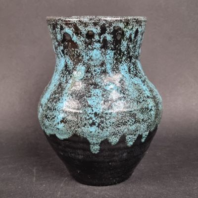 un vase bleu et noir posé sur une table