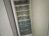 a small refrigerator that is sitting in the corner of a room