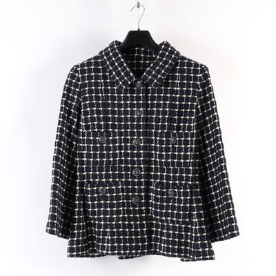 une veste noire et blanche suspendue à un cintre