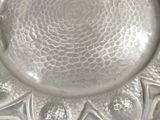 a silver plate with a flower design on it