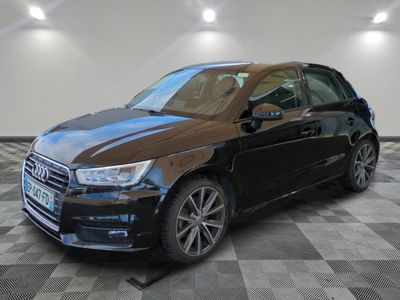 the black car is parked on a checkered floor in the garage