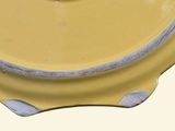 a yellow bowl with a lid on a white table