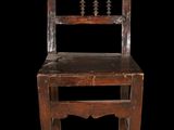 an old wooden chair sitting on top of a black floor