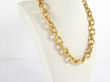 a close up of a mannequin wearing a gold chain necklace