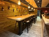 une longue table en bois avec des tabourets dans un restaurant
