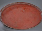 une assiette rouge bordée d'argent sur une table blanche