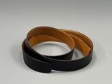 two black and brown leather belts on a white surface