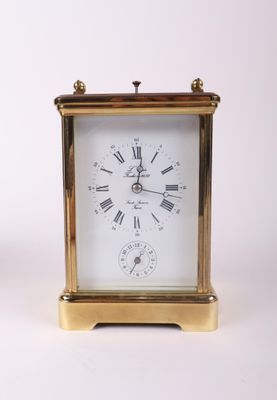 a small gold clock with roman numerals on it