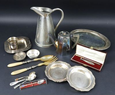 une assiette en argent et des couverts en argent posés sur une table
