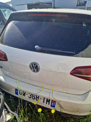 a white car parked next to a bicycle on the grass