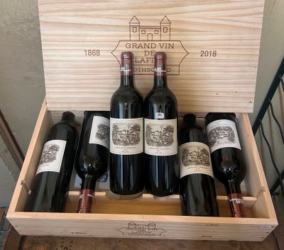 bottles of red wine in a wooden box on a table