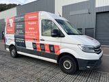 the van is parked in front of a building with a sign on it
