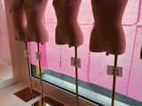 trois mannequins exposés devant une vitrine dans une pièce rose