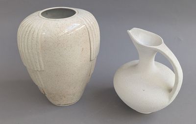 deux vases blancs posés l'un à côté de l'autre sur une table