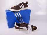 Chaussures adidas Superstar marron et blanches, présentées dans une boîte bleue