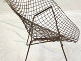 a wire chair that is sitting on a white sheet