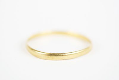 gros plan d'une bague en or sur une surface blanche