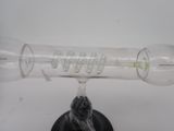 a glass bottle with a pipe inside of it on a stand
