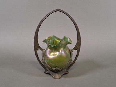 a green vase sitting on top of a metal stand