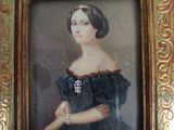 portrait of a woman in a black dress in a gold frame