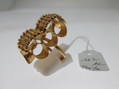 une image d'une bague en or sur une surface blanche avec une étiquette de prix