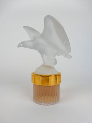 une image représentant un flacon de parfum surmonté d'une figurine d'oiseau