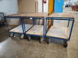 three wooden tables on wheels in a room