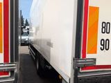two trucks that are parked next to each other in a parking lot