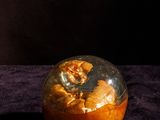 a glass jar with food inside of it on a purple cloth