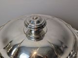 a silver plate with a silver lid on a table
