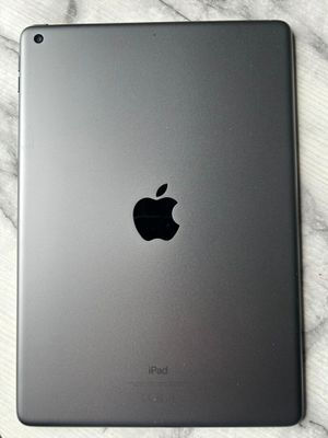 un iPad d'Apple posé sur une table en marbre, à côté d'une tasse de café
