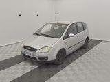 a small white car parked in a room with a checkered floor