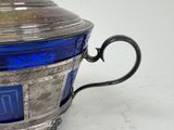 a silver and blue glass teapot on a white table