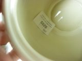 a person holding a white cup with a label on it