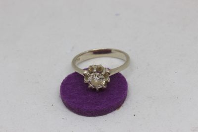 a close up of a diamond ring on a purple surface