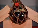 a bottle of liquor hanging from a rope on the wall