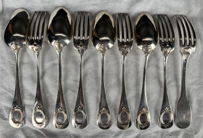 six forks and six spoons on a table
