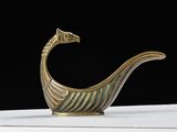 an image of a gold colored bird shaped object on top of a white table