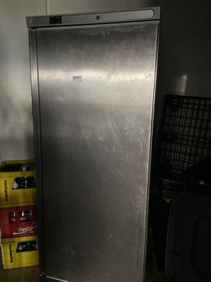a stainless steel refrigerator in a room with boxes of beer
