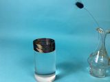 un vase en verre contenant une fleur, à côté d'un autre vase en verre contenant une fleur
