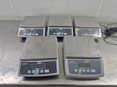 quatre balances électroniques posées sur une table dans une pièce