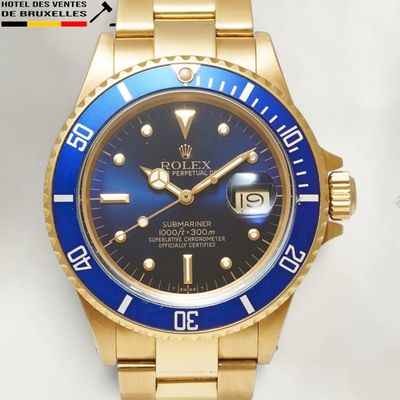 a gold wrist watch with a blue dial on it