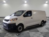 la camionnette blanche est garée dans une grande pièce au sol en damier