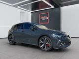 a grey car parked in a garage with a red sign on the wall
