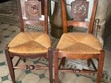 two wooden chairs sitting next to each other on a tiled floor